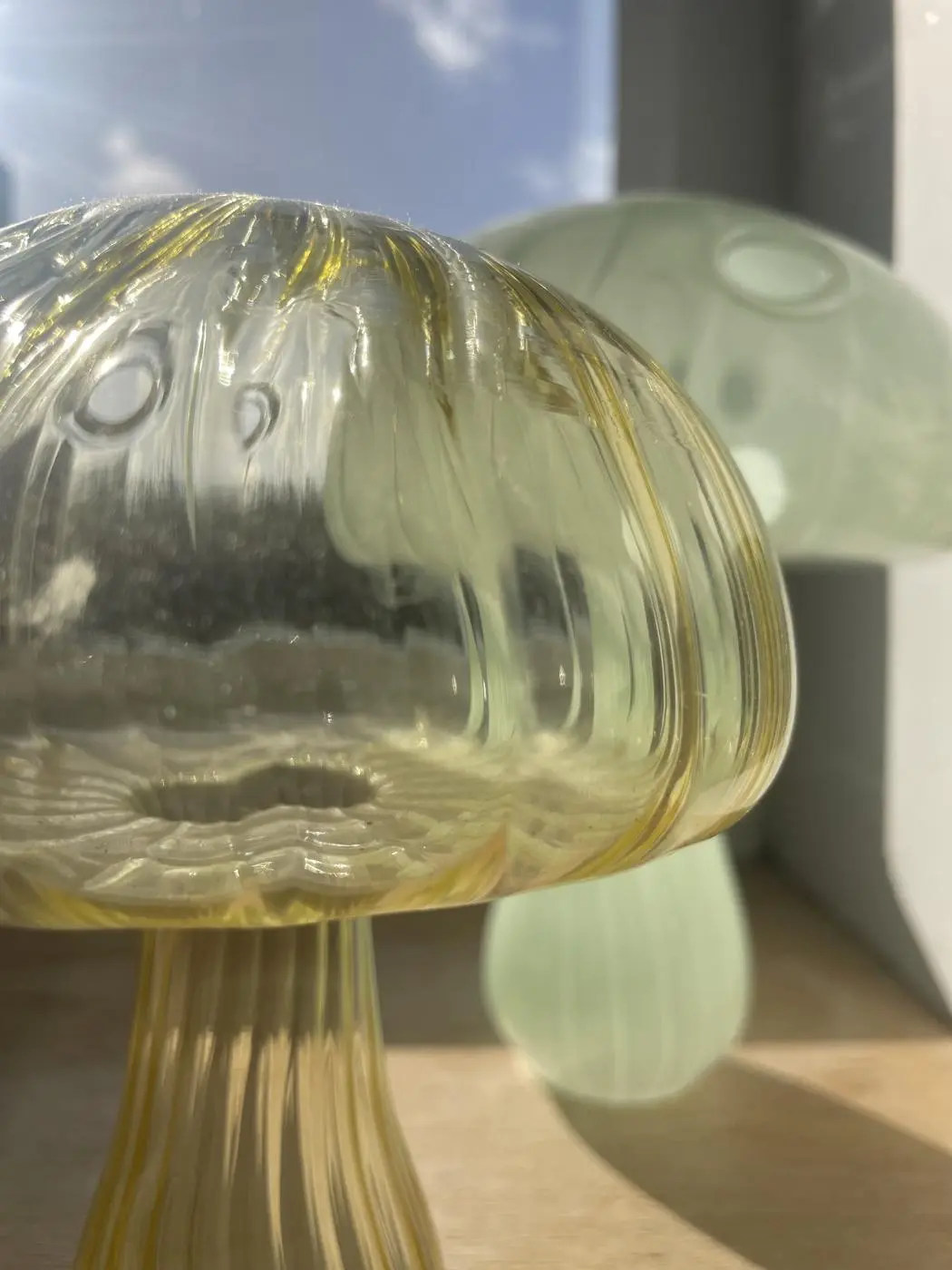 Glass mushrooms on the windowsill in the sun