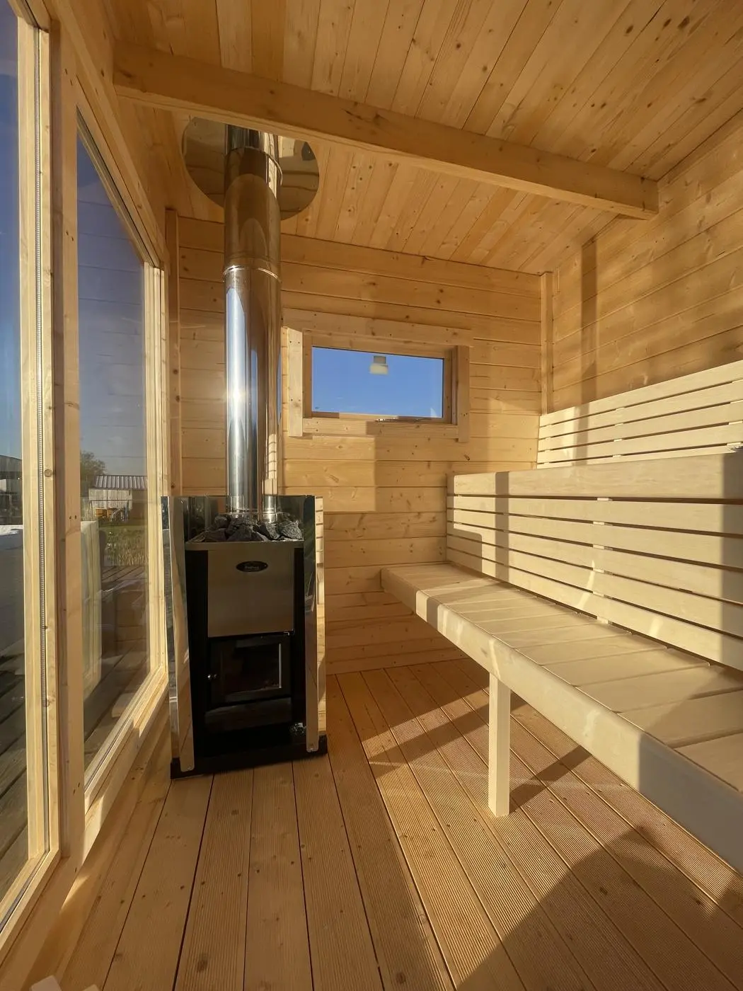 Inside the wood-fired sauna: pale timber benches and the stove